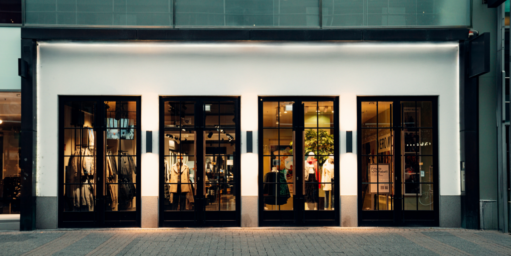Modern clothing store with dark interior and glass windows