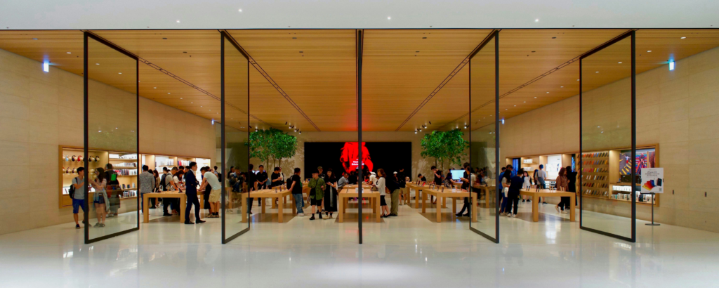 Modern electronics store with open glass doors and customers browsing