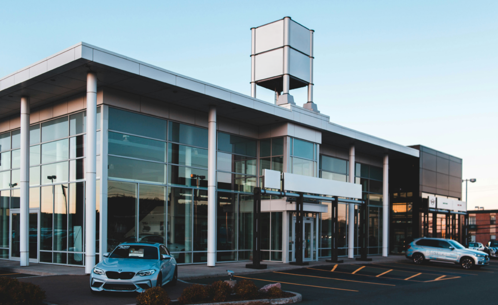 Modern car dealership with glass exterior and parked vehicles